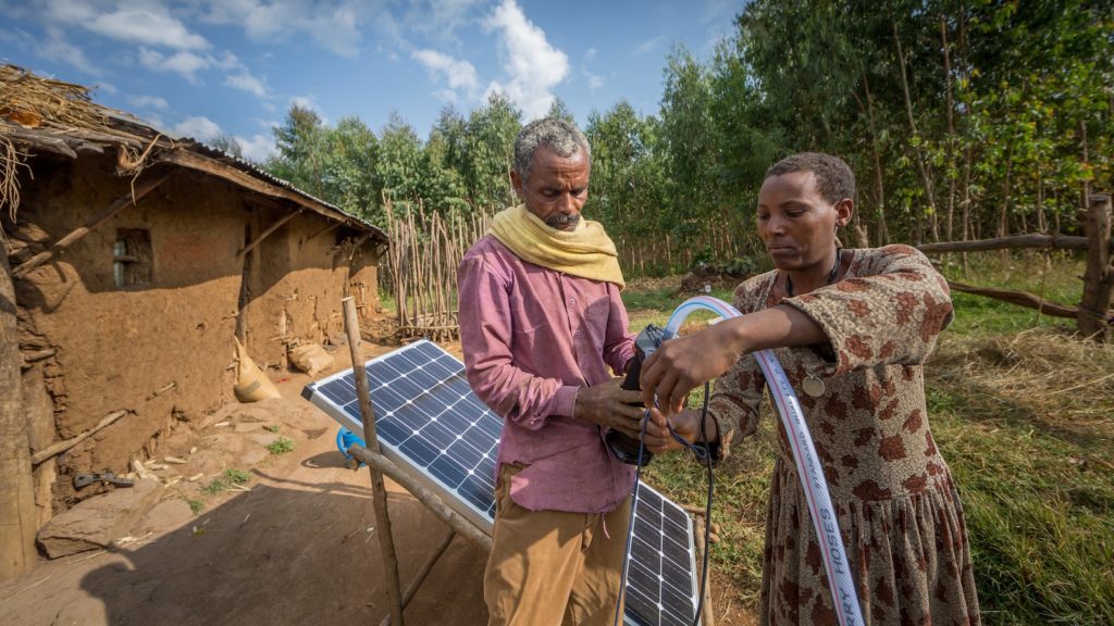 Sewagegn, a local smallholder farmer, and Gebeyaw, a data collector, set up Sewagegn's solar powered pump to irrigate her backyard garden in Danghesta, Amhara region of Ethiopia. Photo by Mulugeta Ayene/WLE.